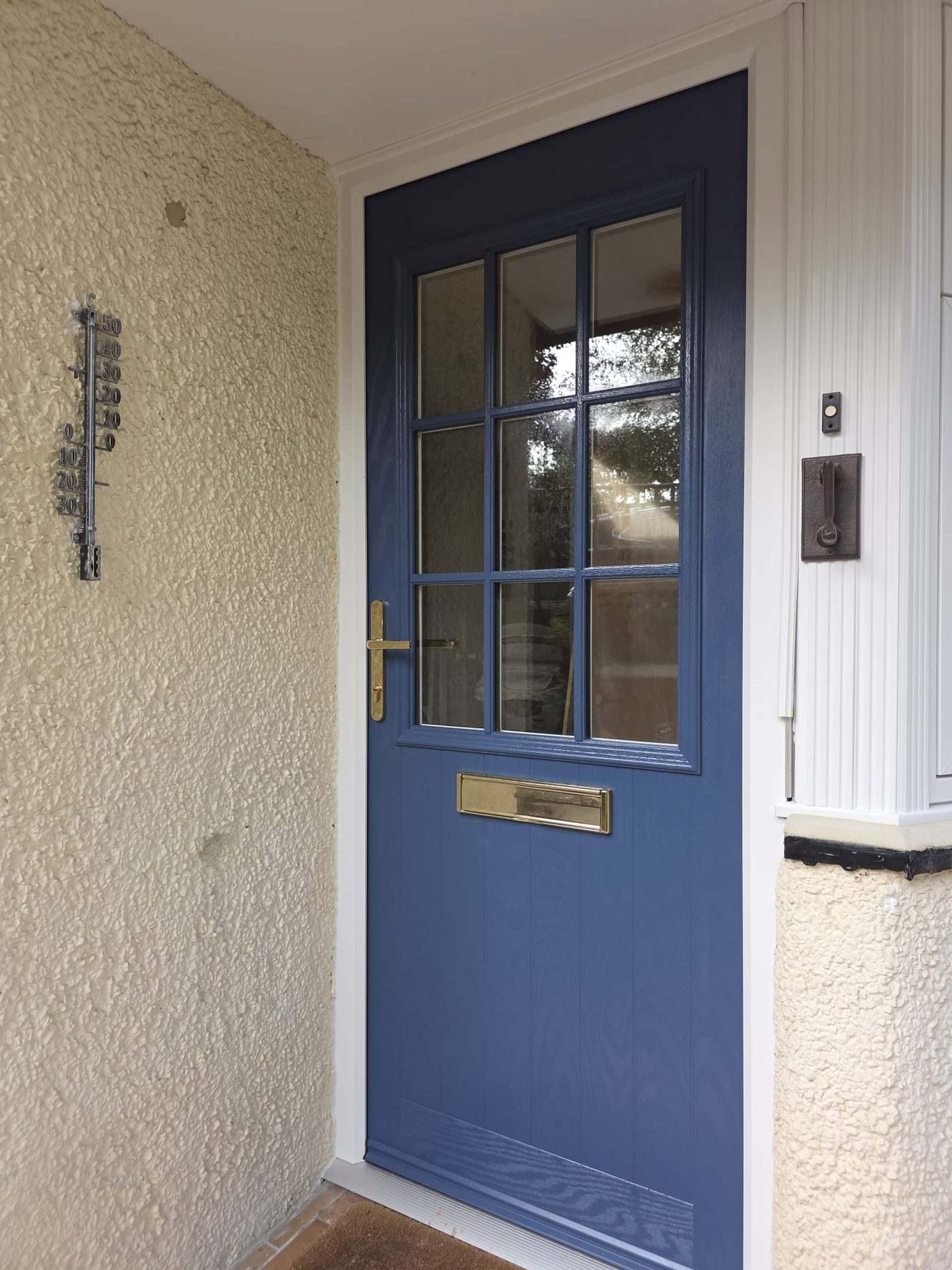 Navy blue composite replacement front door with glazed side panel installed in Hexham