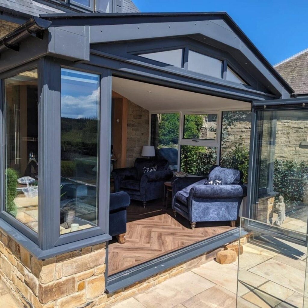 Aluminium bi-fold doors folded fully open connecting kitchen and garden
